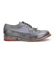 Gray leather Wingtip Toe oxford shoe by Bed|Stü, model Lita K, featuring black laces, elegant brogue details, and a low wooden sole with a red accent on the heel, shown in profile on a white background.