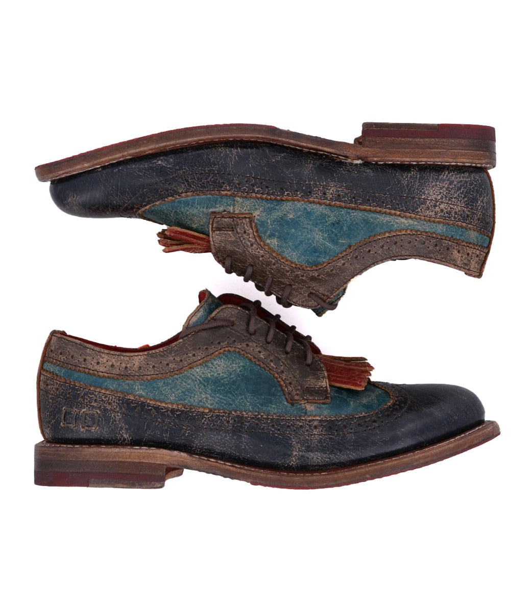 Two worn leather Lita K dress shoes by Bed|Stü, one stacked upside down on top of the other, feature brogue details and subtle teal and brown coloring against a white background.
