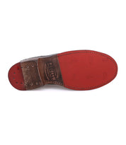 The image shows the bottom view of a brown and red leather dress shoe by Bed|Stü, featuring visible stitching, branding on the sole, and classic brogue details along the wingtip toe. The shoe model is Lita K.