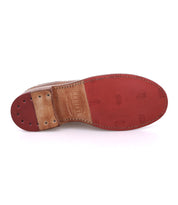 A close-up of the sole of the Bed|Stü Lita K brown leather dress shoe, highlighting detailed stitching, red tread, brogue accents along the edges, and Bed|Stü branding on the heel.