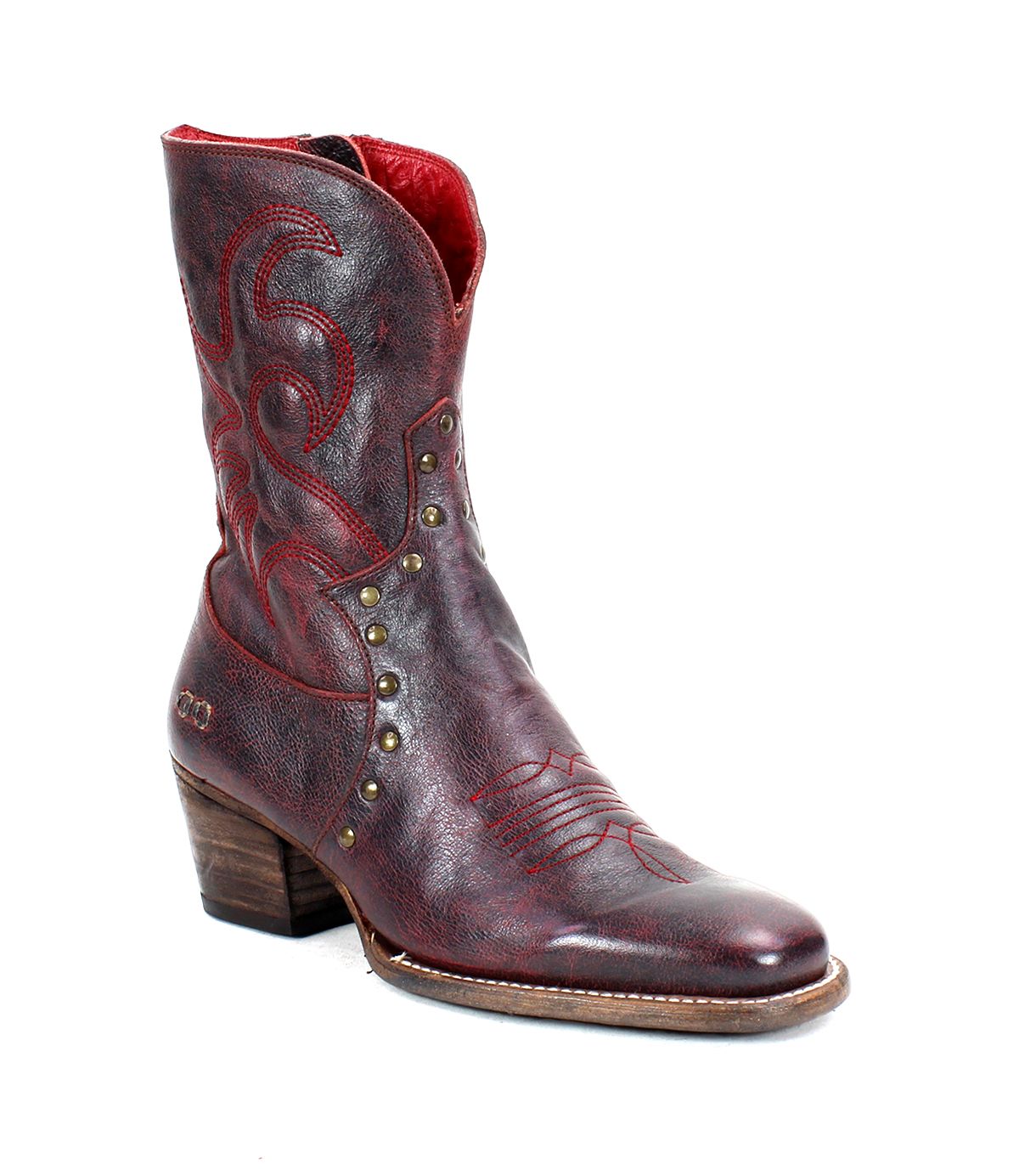 The Locate by Bed|Stü is a single dark red leather Western boot featuring decorative flame stitching, metal studs, a stacked wooden heel, a slightly pointed toe, and a convenient side zipper.