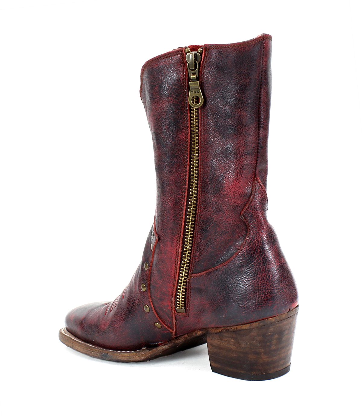 The Bed|Stü Locate features distressed red leather, a side zipper, intricate flame stitching, metallic studs, and a chunky wooden heel.