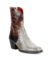 Introducing Locate by Bed|Stü: a single mid-calf Western boot crafted from gray and brown leather, featuring a pointed toe, decorative flame stitching, metal rivets, a convenient side zipper for easy wear, and a chunky black heel.