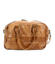 The Luke by Bed|Stü is an oversized tan leather duffle bag made from vegetable-tanned leather, featuring double handles, an adjustable shoulder strap, and a zippered top closure, shown against a white background.