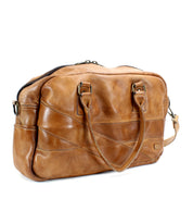 Luke travel bag by Bed|Stü in light brown vegetable-tanned leather, featuring two handles, a detachable shoulder strap, and a zipper closure, displayed against a white background.