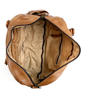 Top-down view of the Bed|Stü Luke travel bag in brown vegetable-tanned leather, featuring a beige fabric lining, an inner zippered pocket, and open side pockets.
