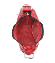 Top view of an open Madre handbag by Bed|Stü in statement-making red, featuring a zipper closure and metal studs for an edgy touch. The image displays an empty main compartment alongside a smaller inner pocket.