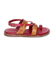 Introducing the Manati II by Bed|Stü — a handcrafted leather sandal with red and tan leather straps, an adjustable buckle, and a red cushioned sole for that barefoot feeling, shown from the side.
