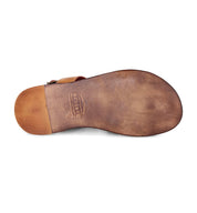 The image shows the worn brown leather sole of a handcrafted leather sandal, the Manati II by Bed|Stü, with the brand name stamped near the heel and evoking a natural, barefoot feeling.