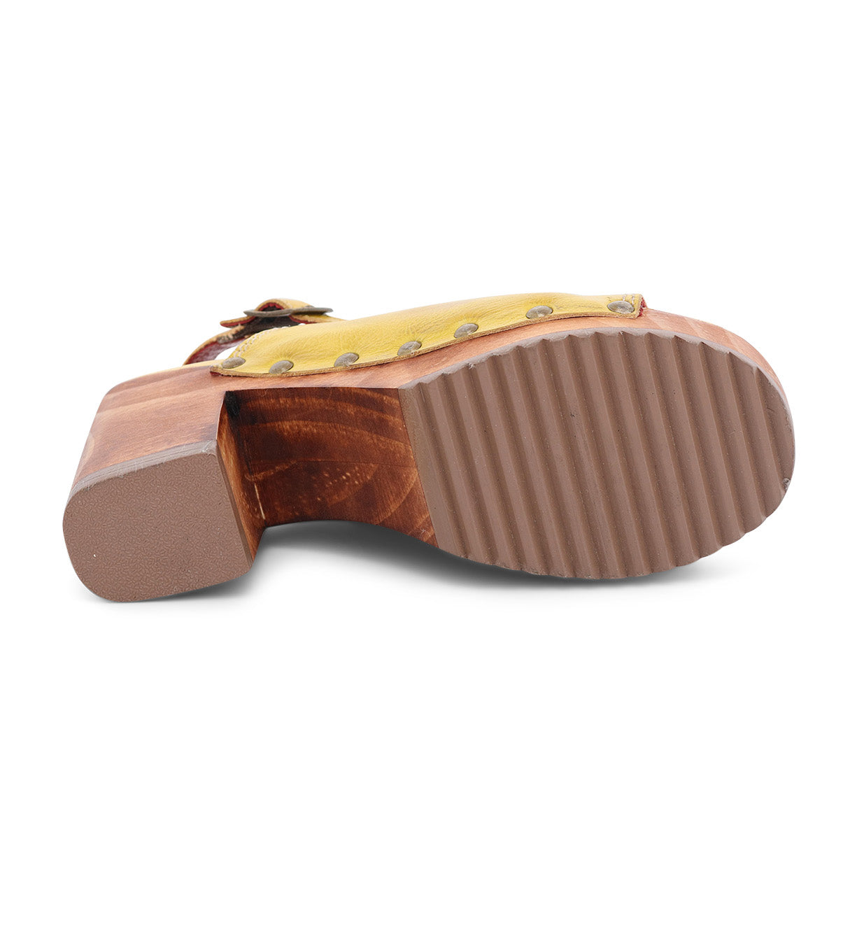 The image shows the bottom view of the Bed|Stü Marie sandal, featuring a yellow vegetable tanned leather upper, a wooden heel, and a ribbed brown rubber sole.