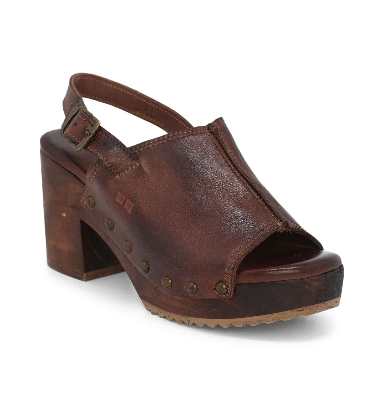 The "Marie" sandal by Bed|Stü is a brown leather clog featuring an open toe, a thick wooden platform heel, a slingback strap with buckle closure, and metal stud accents along the sole.