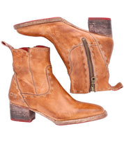 Introducing Merryli by Bed|Stü: a pair of brown leather ankle boots with block heels, side zippers, and visible stitching. Red accents on the soles and inner lining add a distinctive touch to these hand-stitched boots, which showcase a refined finish that highlights their craftsmanship and durability.