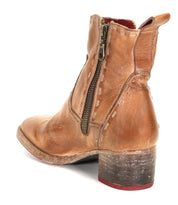 The Merryli by Bed|Stü is a hand-stitched brown leather ankle boot featuring visible stitching, a side zipper, and a chunky heel. Viewed from the back and side, this boot exemplifies classic craftsmanship and timeless style.