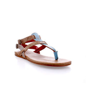 The Bed|Stü Moon sandal is a flat leather style with tan, blue, and red straps, featuring a cushioned insole, a toe loop, and a secure ankle buckle, displayed on a white background.