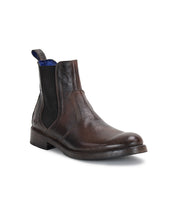 The Nando by Bed|Stü is a brown hand-worked leather Chelsea boot featuring black elastic side panels, a pull tab, and a low stacked heel, shown on a white background.