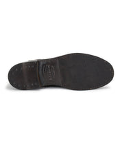 The image shows the sole of the Bed|Stü Nando, a dark brown leather dress shoe featuring visible stitching and metal tacks in the heel area, which highlight its Goodyear welt construction—a hallmark of high-quality, hand-crafted footwear.