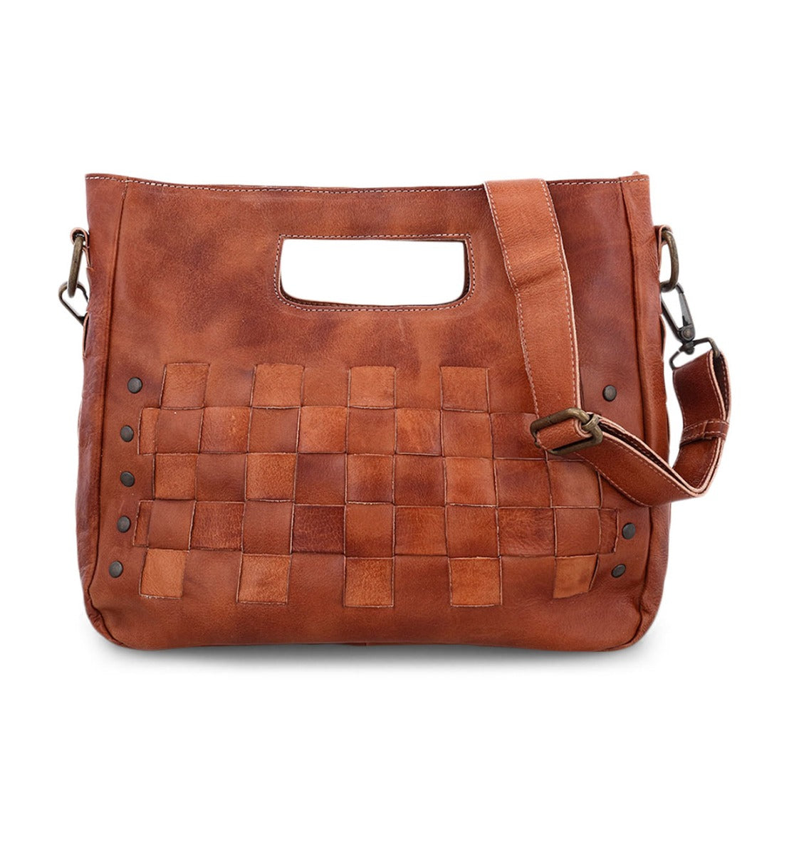 The Bed|Stü Orchid is a brown leather handbag featuring a handwoven front pattern, integrated handle cutout, removable shoulder strap, and metal rivet accents—an artisanal bag that blends modern style with timeless appeal for any occasion.