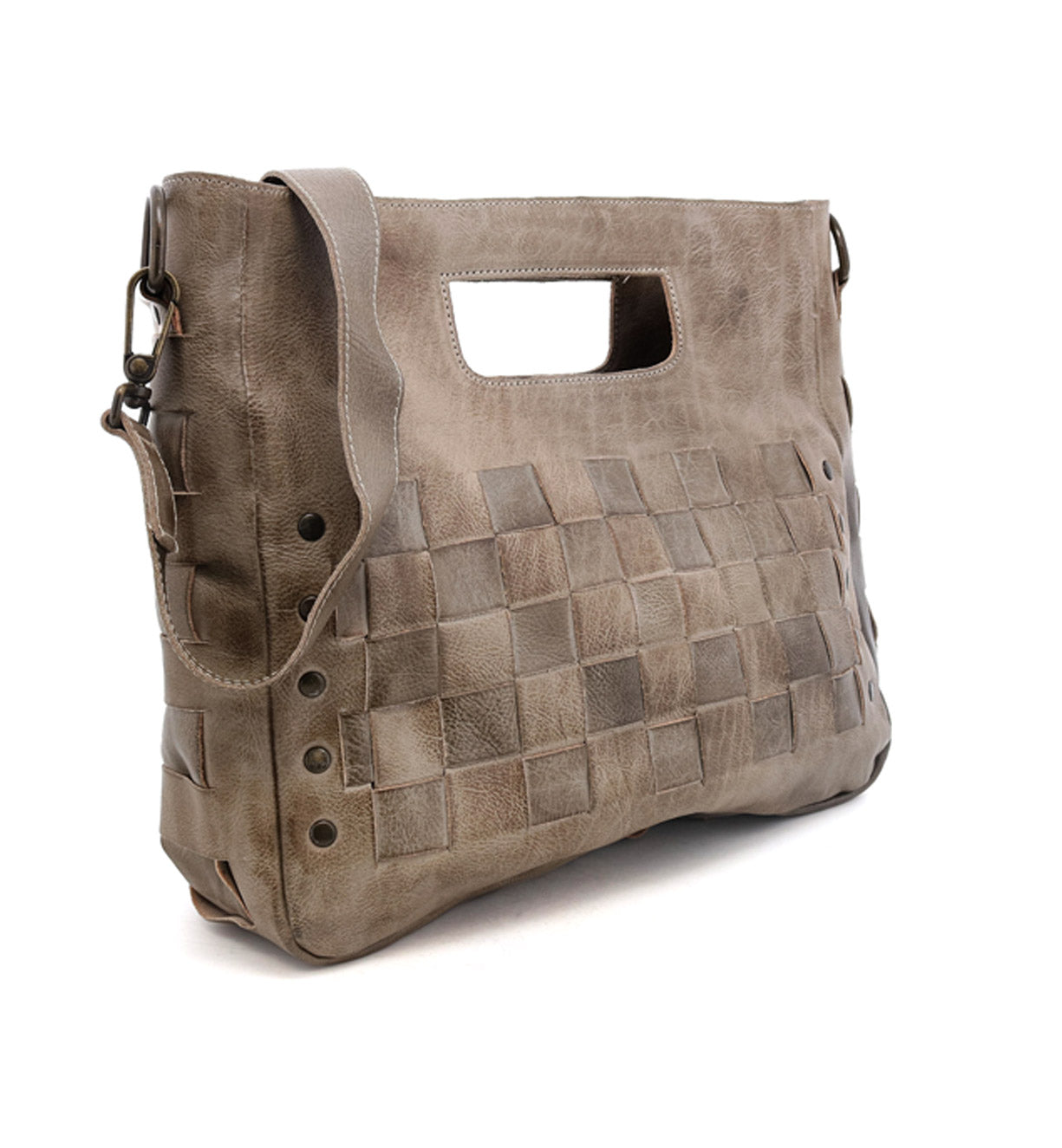 Introducing Orchid by Bed|Stü—a taupe leather handbag featuring a woven front pattern, wide shoulder strap, antique metal buckle, and a unique cutout handle, all crafted for a modern yet timeless style.