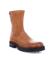 The Ploy ankle boot by Bed|Stü, crafted from brown Italian leather, showcases a stylish square toe, dual side zippers, and a thick black rubber sole, displayed on a white background.