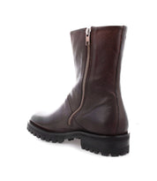 Bed|Stü Ploy boot in dark brown Italian leather, featuring dual side zippers and a sturdy lug sole, displayed from a rear side angle on a plain white background.