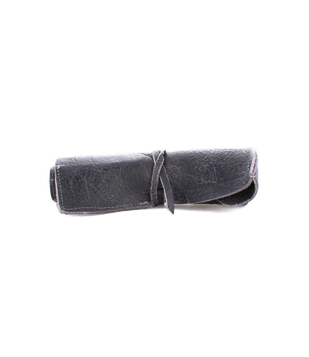 The Prepped Leather Wrap by Bed|Stü is a dark gray leather roll-up organizer, secured with a leather strap—perfect for artists who want a stylish and practical way to keep their tools organized.