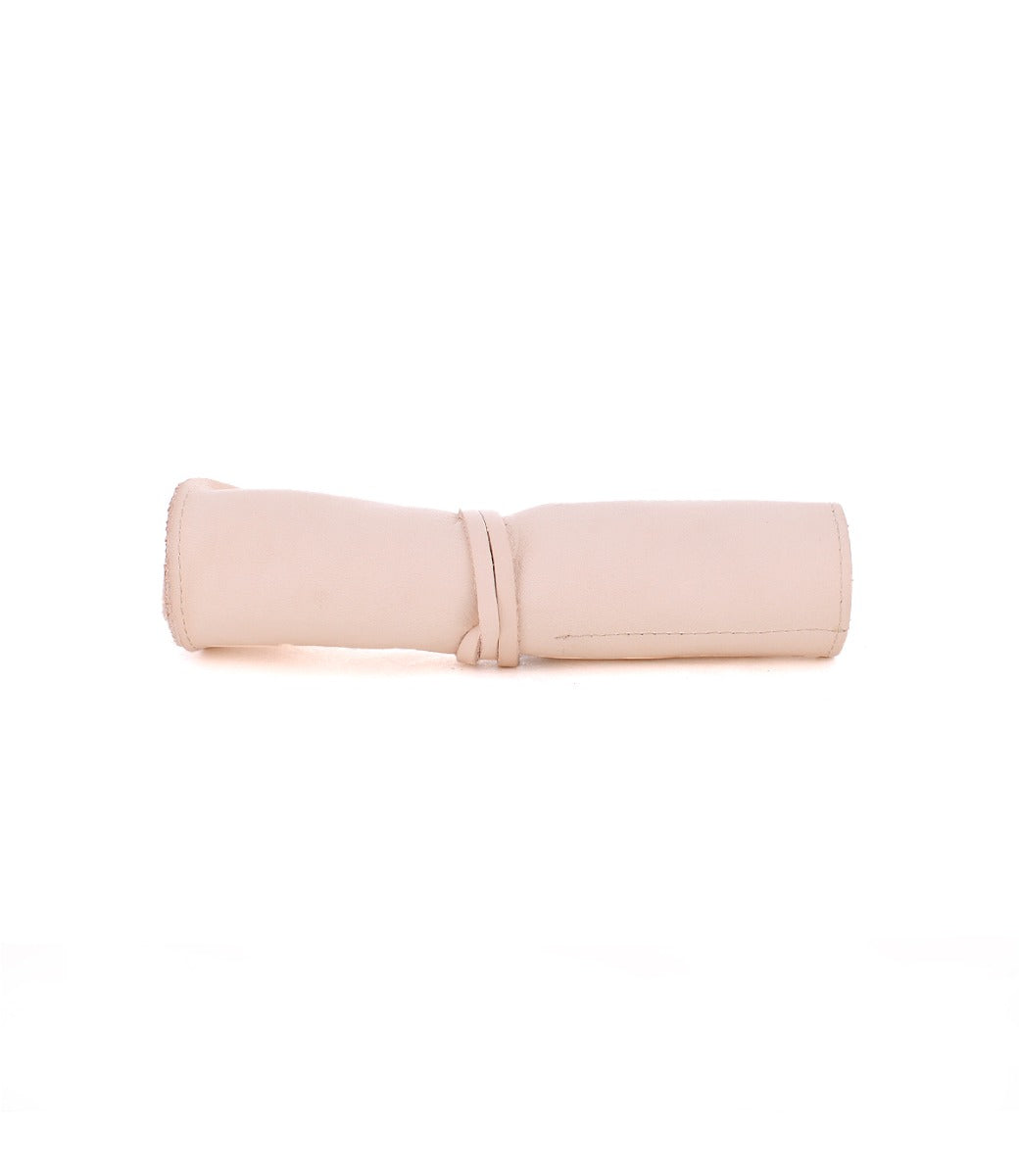 The Bed|Stü Prepped Leather Wrap, shown rolled up with a coordinating leather tie in light beige on a white background, offers artists a sophisticated and practical storage solution.