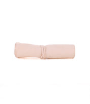 The Bed|Stü Prepped Leather Wrap, shown rolled up with a coordinating leather tie in light beige on a white background, offers artists a sophisticated and practical storage solution.