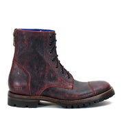 The Bed|Stü Protege Trek is a single dark red leather combat boot featuring a textured finish, thick treaded sole, visible back zipper, and crafted with a Goodyear welt for added durability.