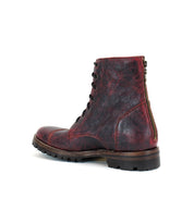 Introducing the Protege Trek by Bed|Stü: a leather lace-up combat boot featuring a textured red and black finish, dark treaded sole, visible stitching, and a convenient heel zipper. Built for durability with Goodyear welt construction, this boot is designed for long-lasting wear.