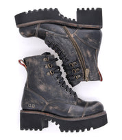 A pair of Bed|Stü Prudence Hi distressed black leather combat boots with thick lug soles, a chunky platform outsole, metal eyelets, side zippers, and a red pull tab at the heel are displayed against a white background—perfect for those seeking truly edgy boots.