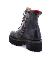 Prudence Hi by Bed|Stü is a black leather combat boot featuring a lace-up front, side zipper, chunky platform outsole, and a thick treaded sole with a slightly worn finish, displayed from a rear side angle on a white background.
