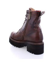 The Bed|Stü Prudence Hi is a brown leather combat boot featuring a side zipper, lace-up front, and thick black treaded sole with a chunky platform outsole, shown from the rear side angle against a white background.