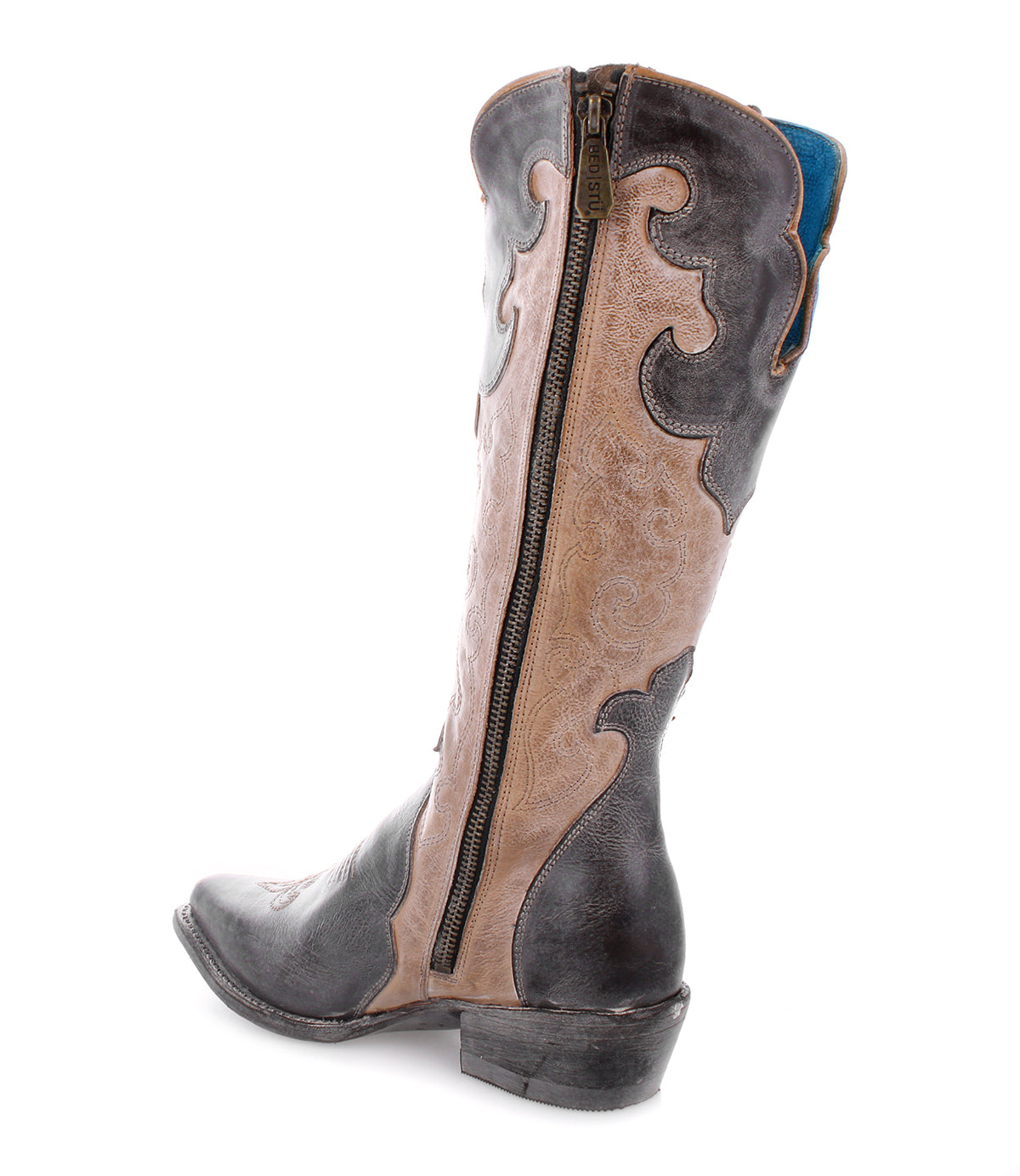 Introducing the Bed|Stü Queen boot—a tall Western silhouette featuring elegant Fleur-de-lis accents, decorative stitching, and a convenient side zipper. Crafted from two-tone brown vegetable-tanned leather, this stylish boot boasts a low heel and showcases a distinctive blue lining at the top.