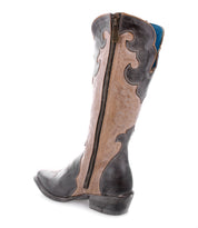 Introducing the Bed|Stü Queen boot—a tall Western silhouette featuring elegant Fleur-de-lis accents, decorative stitching, and a convenient side zipper. Crafted from two-tone brown vegetable-tanned leather, this stylish boot boasts a low heel and showcases a distinctive blue lining at the top.