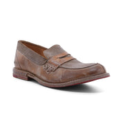 A single Reina penny loafer by Bed|Stü, featuring a brown, worn leather upper with visible scuffs and Goodyear welted construction, is displayed on a white background.