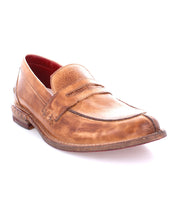 A single Bed|Stü Reina brown penny loafer, crafted with a leather upper and visible stitching, showcases a slightly worn appearance and durable Goodyear welted construction, photographed on a white background.
