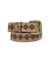 The Roam belt by Bed|Stü features a tan leather strap adorned with a repeating diamond pattern and finished with a brass buckle, drawing inspiration from classic western artistry and refined geometric motifs.