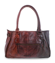 Explore the Rockaway by Bed|Stü—a brown full-grain leather handbag featuring two handles, a front zipper pocket, and decorative stitching, designed for everyday use and pictured against a white background.