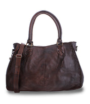 The Bed|Stü Rockaway is a dark brown handbag crafted from full-grain leather, featuring two handles and a detachable shoulder strap for everyday function, shown against a white background.