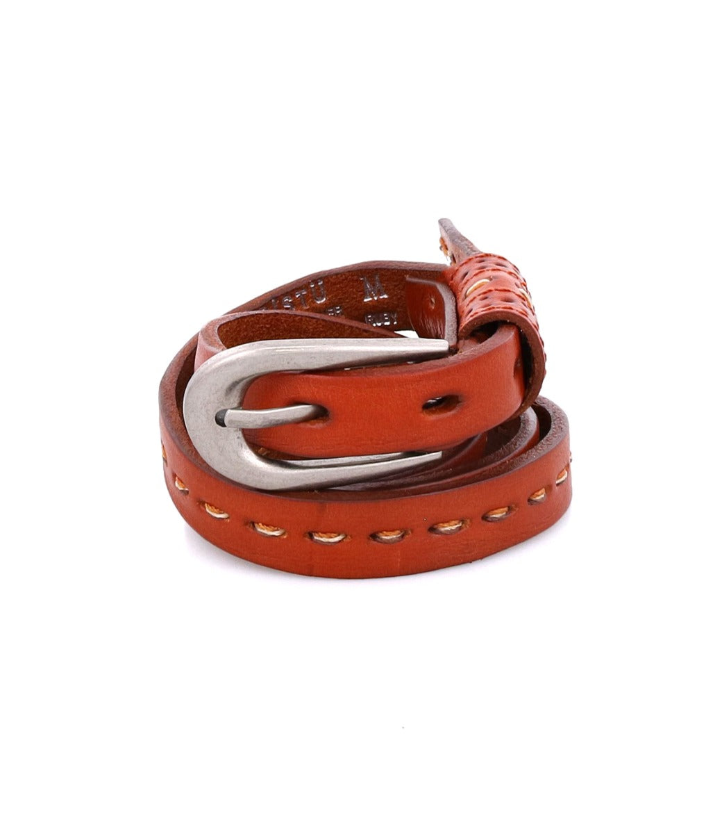 Introducing the Ruby by Bed|Stü: a coiled brown leather belt featuring contrast stitching and a silver metal buckle, showcased against a white background.