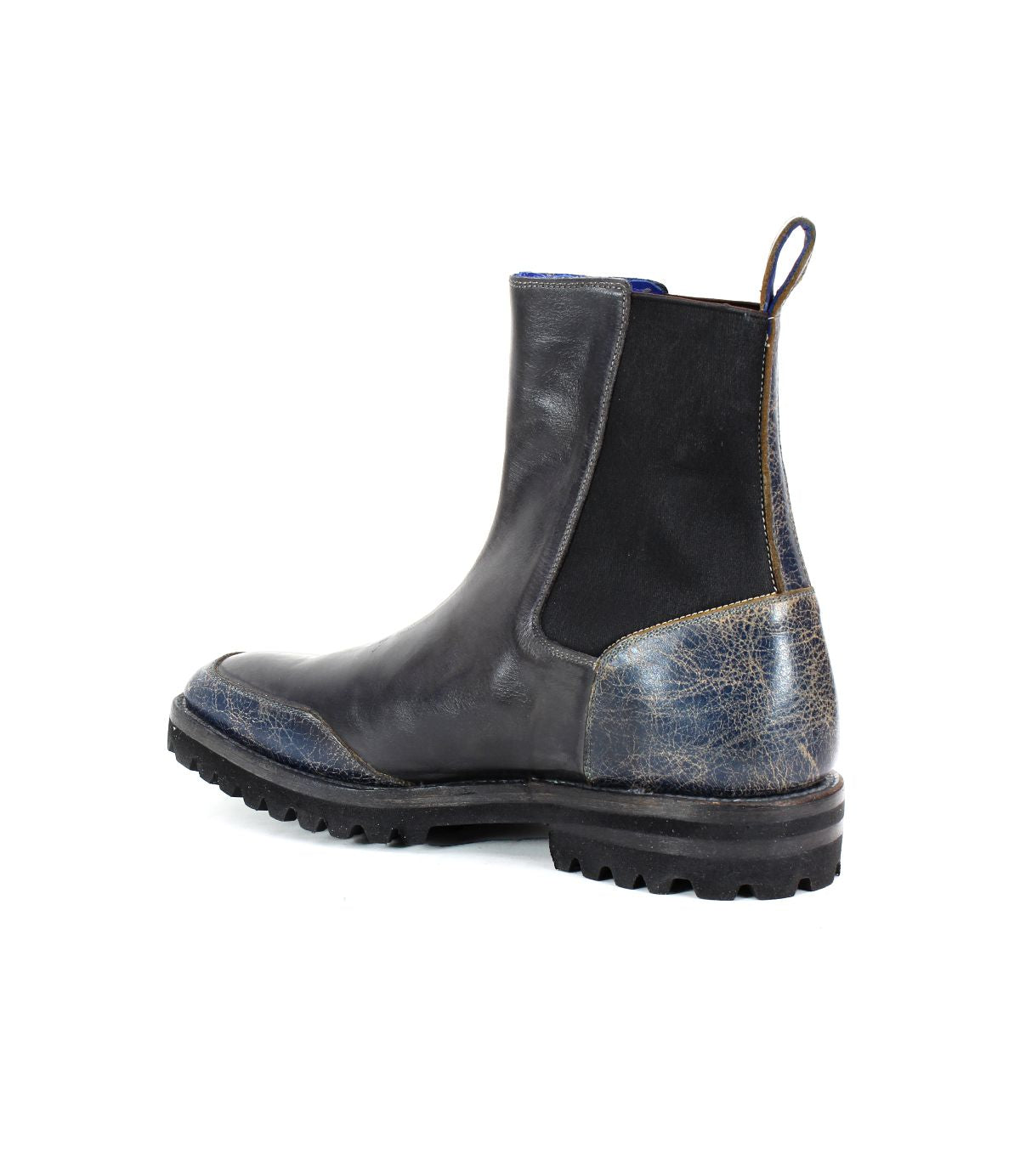 The Salatiel by Bed|Stü is a black Chelsea boot with a thick, textured outsole and a distressed blue heel, shown from the side and slightly behind. It features a cushioned leather footbed for all-day comfort.