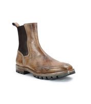 The Bed|Stü Salatiel is a brown leather Chelsea boot featuring black elastic side panels, a pull tab at the back, and a thick rubber sole with a textured outsole and cushioned leather footbed, shown against a white background.