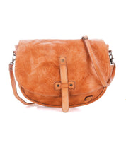 The Bed|Stü Sequoia EM is a tan vegetable-tanned leather crossbody bag featuring a flap closure, detailed embossed pattern, and an adjustable shoulder strap, shown against a plain white background.