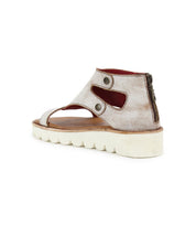 Presenting the Bed|Stü Soni II: a single metallic platform sandal featuring a sturdy white sole, side cutouts, two metal snap closures, striking red inner lining, and a convenient back zipper. Designed for comfort and durability, the Soni II combines lasting wear with distinctive style.