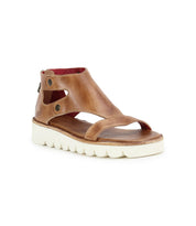 The Bed|Stü Soni II is a brown leather sandal featuring an ankle strap, open toe, and a white textured durable outsole, displayed on a white background.