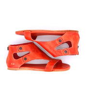A pair of flat, open-toe orange Soto sandals by Bed|Stü, featuring cutout leather with button details and a cushioned footbed, stacked sole-to-sole against a white background—perfect for everyday exploring.
