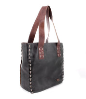 The Stevie tote by Bed|Stü is a black leather bag featuring brown handles and visible white stitching along the edges, making it perfect for everyday carry; shown here photographed on a white background.