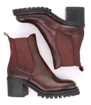 Surge Chelsea boots by Bed|Stü in dark red Italian leather, featuring chunky black heels and elastic side panels, displayed from the side and bottom on a white background.