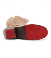 The Bed|Stü Takoma is a single tan leather boot displayed sole-up, revealing a red base with small embossed logos and prominent stitching; it showcases a western-style heel and an asymmetrical top for added style.