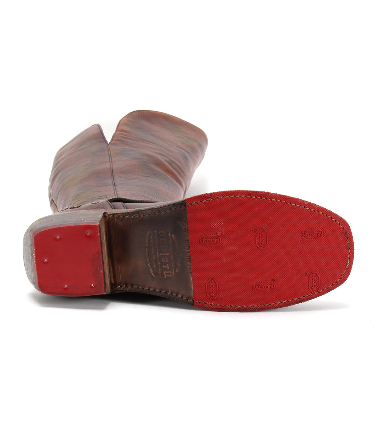 The Bed|Stü Takoma is a brown leather cowboy boot displayed from the sole, featuring a square toe, red Vibram sole and heel with visible stitching, western-shaped heel, brand markings, and an asymmetrical top design.